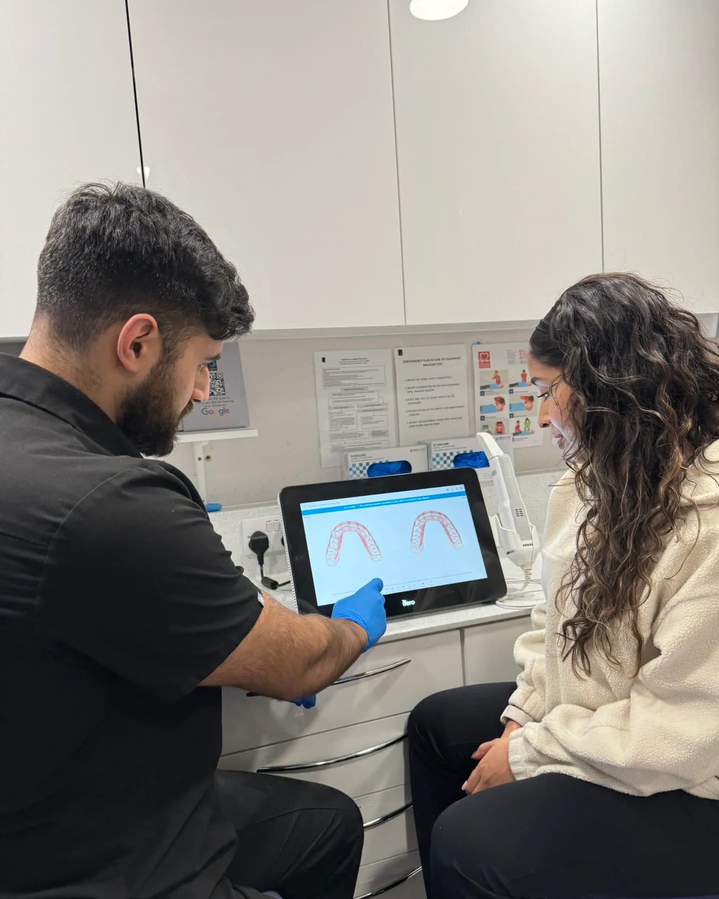 A Dental Works dentist talking a patient through her digital scan